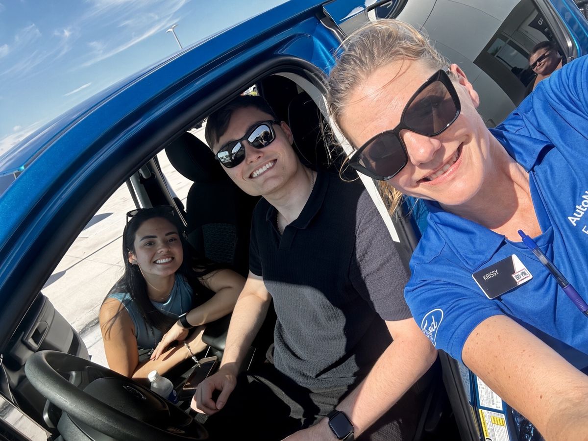Krissy with a young couple in their new blue truck